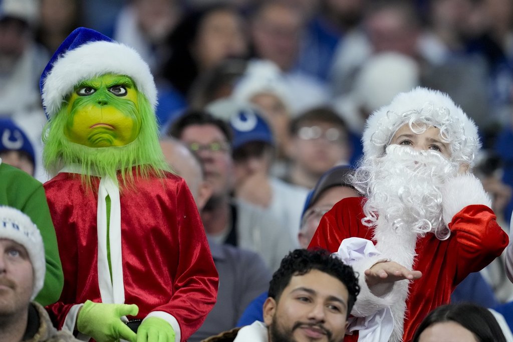 Fans dressed as the Grinch, left, and Santa Claus, right, watch during the second half of an NFL football game between the Indianapolis Colts and the Tennessee Titans, Sunday, Dec. 22, 2024, in Indianapolis.