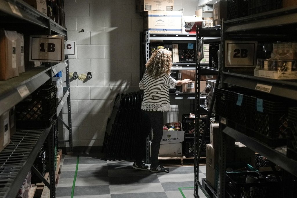 A volunteer works in the storeroom of St. Philip Neri’s Table Food Bank at St Philip Neri Church in Toronto, Friday, Oct. 25, 2024. 