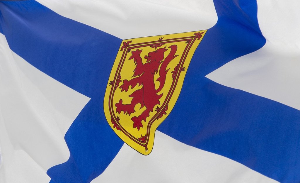 Nova Scotia's provincial flag flies on a flagpole in Ottawa, Friday, July 3, 2020. Cape Breton Regional Police have charged a 57-year-old woman for taking more than $30,000 from the New Waterford Minor Hockey Association.THE CANADIAN PRESS/Adrian Wyld.