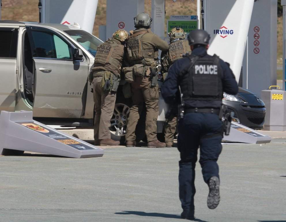 RCMP officers prepare to take a person into custody at a gas station in Enfield, N.S., on Sunday April 19, 2020. THE CANADIAN PRESS/Tim Krochak.