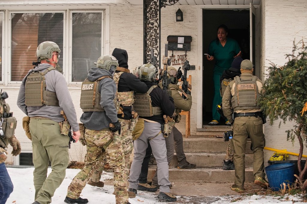 A family member reacts after a federal immigration officer used a battering ram to break down a door before making an arrest Sunday, Jan. 11, 2026, in Minneapolis.