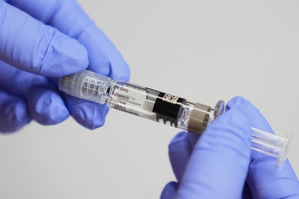 FILE - A certified medical assistant holds a syringe for a flu vaccine at a clinic in Seattle, on Sept. 10, 2025. (AP Photo/Lindsey Wasson, File).