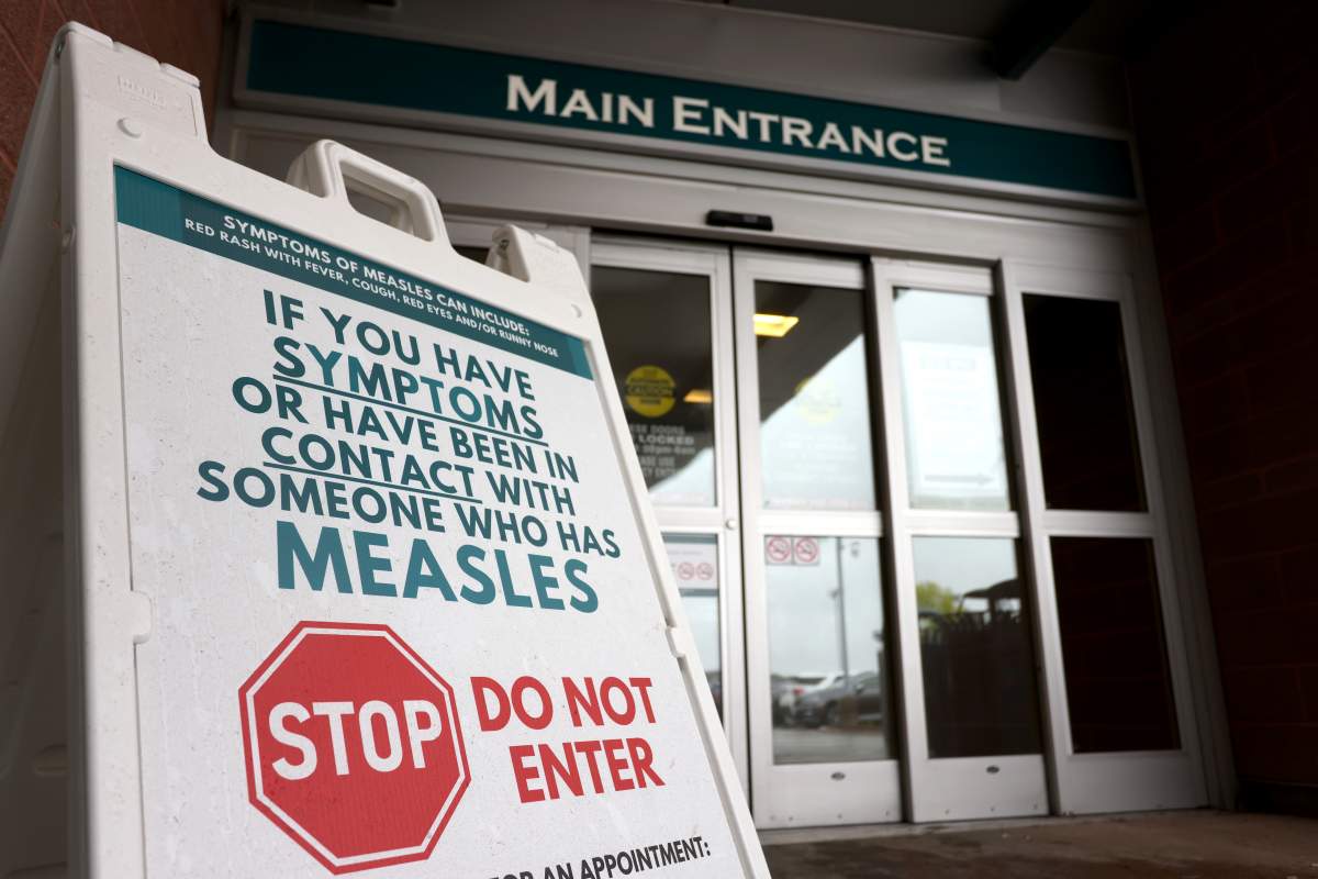 Warning signage outside of a building for suspected measles cases.