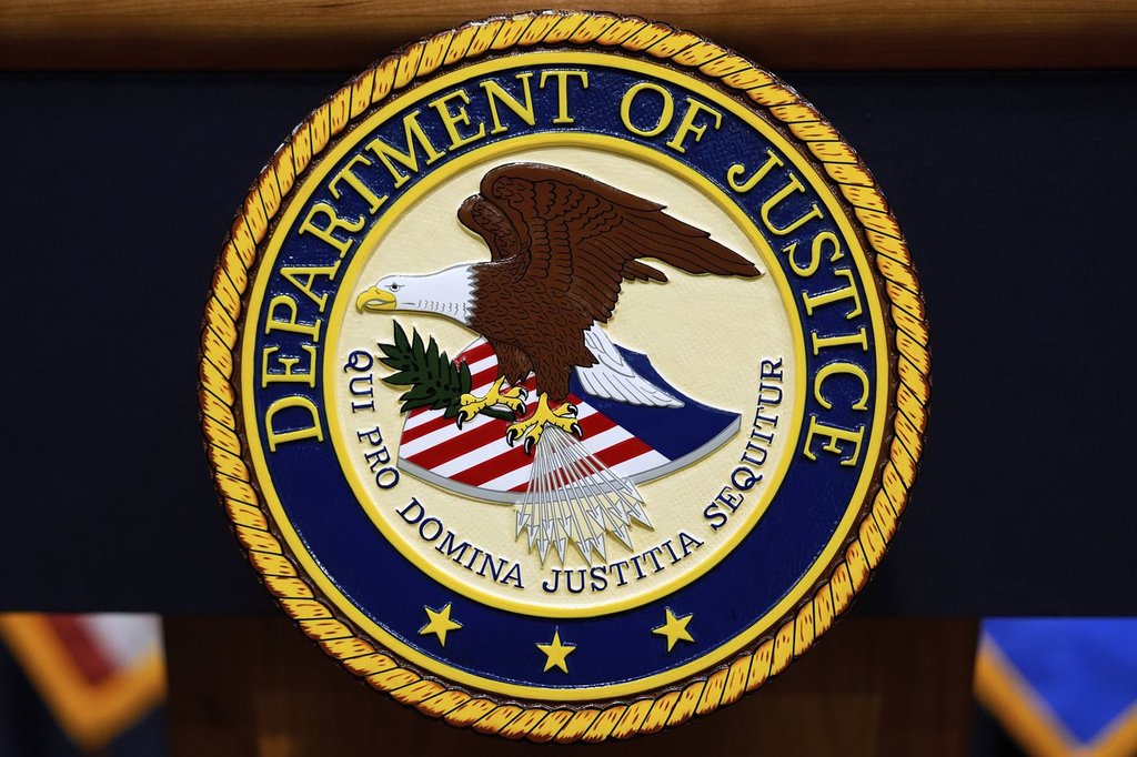FILE - The U.S. Department of Justice logo is seen on a podium before a press conference, May 6, 2025, at the Justice Department in Washington. (AP Photo/Julia Demaree Nikhinson, File).