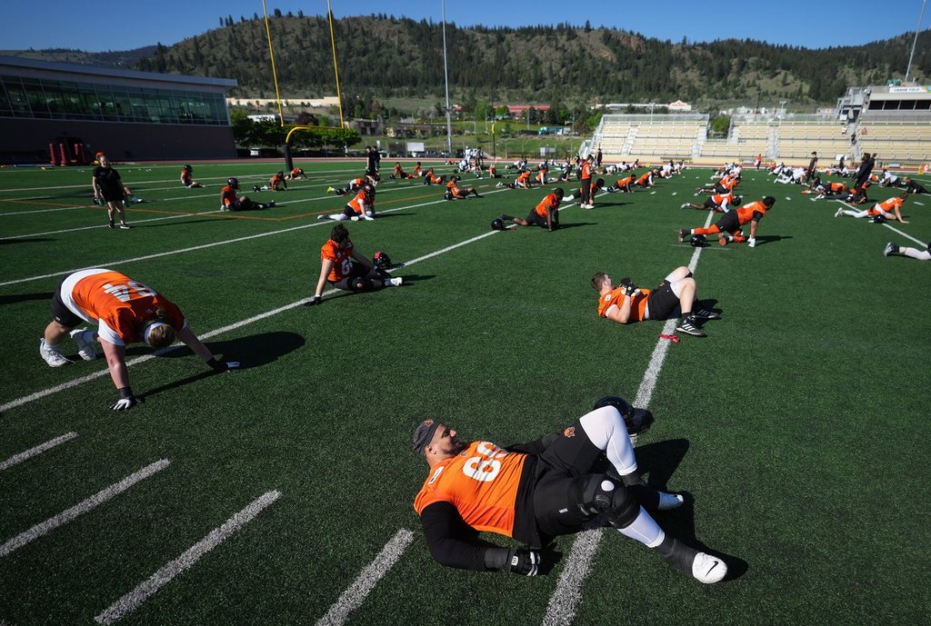 B.C. Lions offensive lineman Jarell Broxton, bottom right, stretches along with the rest of his teammates during the CFL football team's training camp in Kamloops, B.C., on Monday, May 15, 2023. THE CANADIAN PRESS/Darryl Dyck.