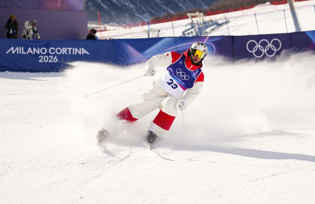 Elliot Vaillancourt from Drummondville, Que., slides into the finish zone as he competes in the men's moguls qualification two at the Milano Cortina 2026 Winter Olympic Games in Livigno, Italy on Thursday, Feb. 12, 2026. THE CANADIAN PRESS/Sean Kilpatrick.
