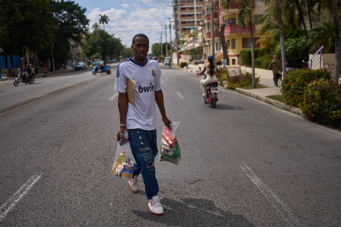 State-run bodega manager Roberto Roman carries bags of donated Mexican humanitarian assistance to be delivered to a family, in Havana, Cuba, Thursday, Feb. 19, 2026.