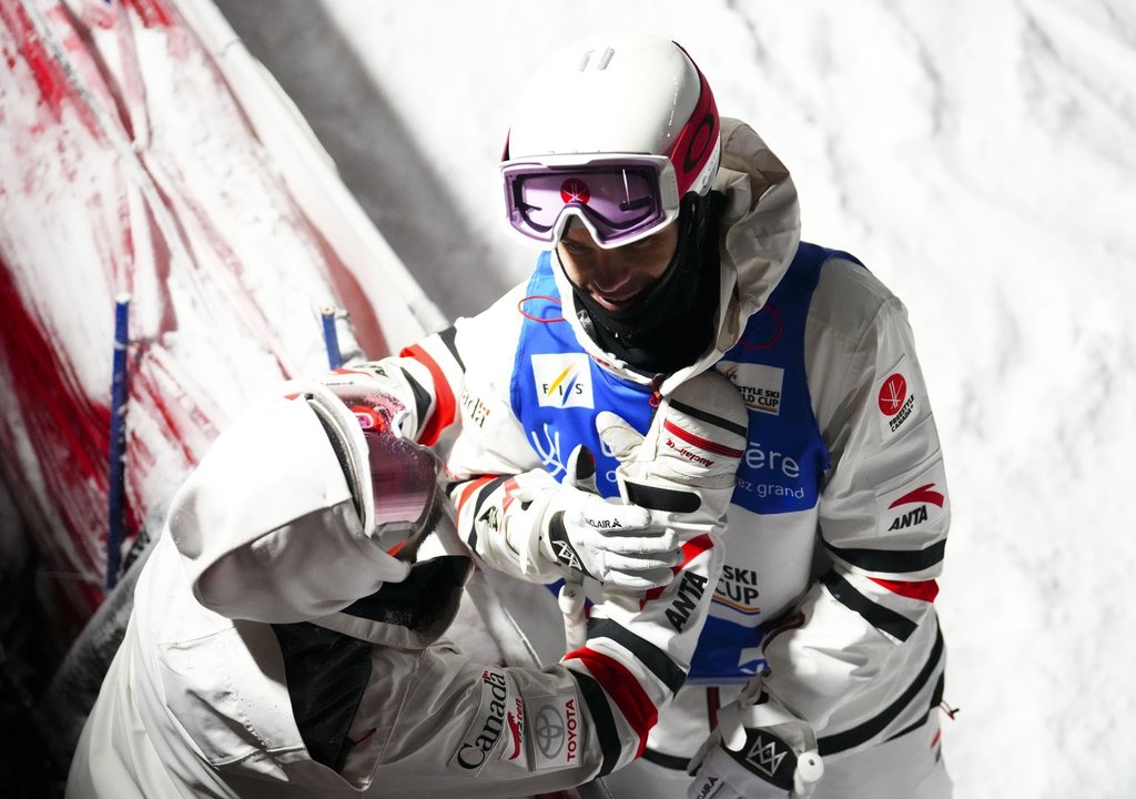 Mikael Kingsbury of Canada is comforted by his coach Michel Hamelin after a crash in the finals of the men's dual moguls freestyle ski world cup at Val Saint-Come, Que., on Saturday, Jan. 28, 2023. Kingsbury placed second. THE CANADIAN PRESS/Sean Kilpatrick.