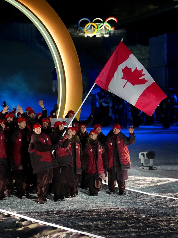 Freestyle skiers Mikael Kingsbury and Marielle Thompson carry the Canada flag during the opening ceremony of the Milan Cortina Olympic Games in Livigno, Italy on Friday, Feb. 6, 2026. THE CANADIAN PRESS/Sean Kilpatrick.