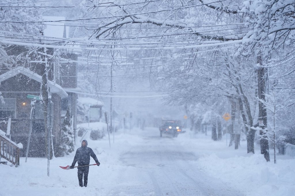 A person pauses while shovelling snow during a winter storm that closed schools and left thousands without power in Halifax on Jan. 19 2026.