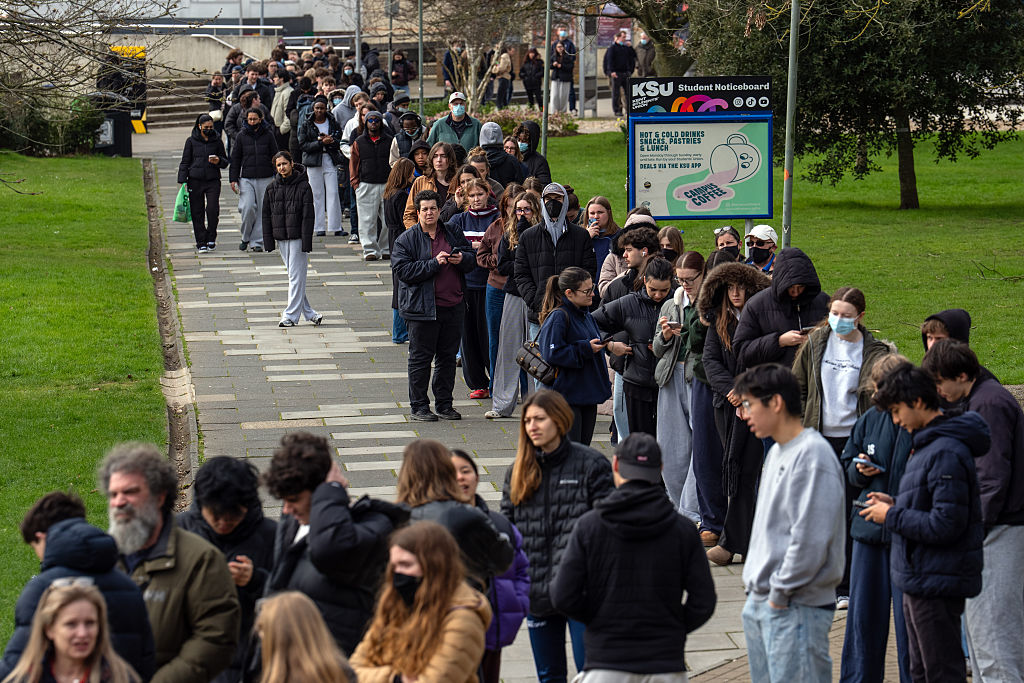Staff and students, some wearing face masks, queue to receive antibiotics at the University of Kent in Canterbury after an outbreak of meningitis caused the deaths of two people, on March 16, 2026 in Canterbury, United Kingdom. Two people have died amid an outbreak of meningitis at the University of Kent in Canterbury. Thirteen cases have been reported since Friday, reportedly affecting university students aged between 18 and 21.