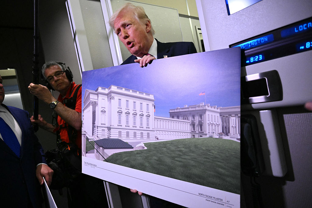 President Donald Trump holds a rendering of the East Wing modernization as he speaks to reporters aboard Air Force One en route to Joint Base Andrews, Maryland, on March 29, 2026.