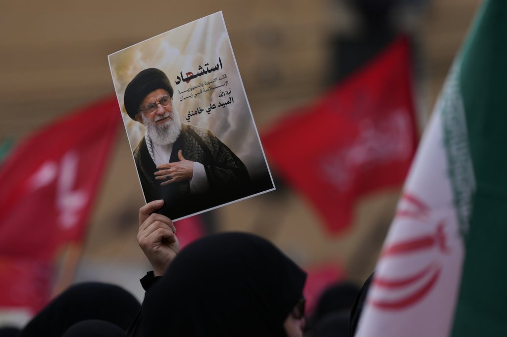 A Hezbollah supporter holds up a portrait of the late Iranian Supreme Leader Ayatollah Ali Khamenei during a gathering in the southern suburbs of Beirut, Lebanon, Sunday, March 1, 2026. The Arabic words on the portrait read:"Martyrdom of the leader of the Islamic revolution in Iran, sayyed Ayatollah Ali Khamenei." (AP Photo/Hassan Ammar).