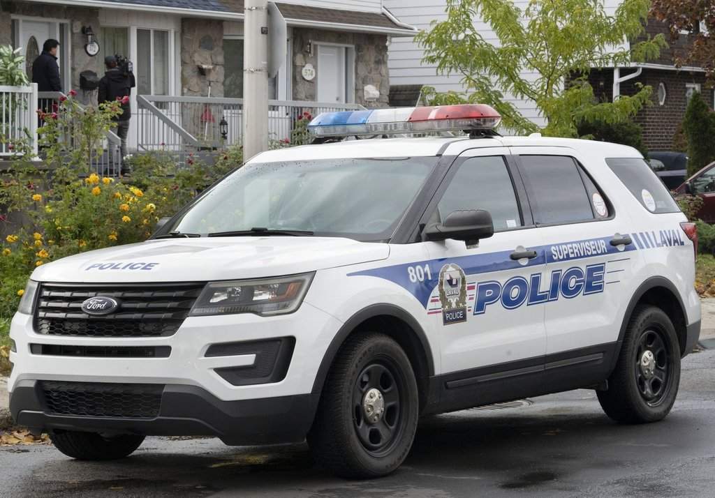 A police vehicle is shown outside a house in Laval, Que., on Tuesday, Oct. 18, 2022, where two children were found dead. 
