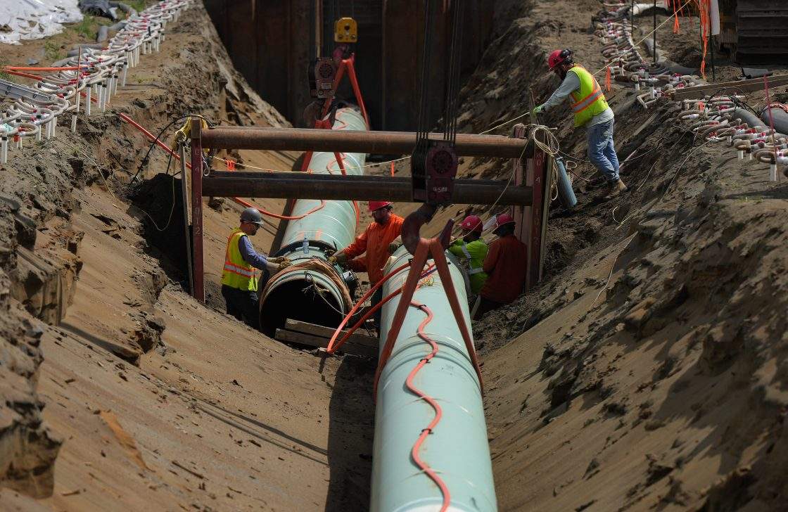 Workers lay pipe during construction of the Trans Mountain pipeline expansion on farmland, in Abbotsford, B.C., on Wednesday, May 3, 2023. 