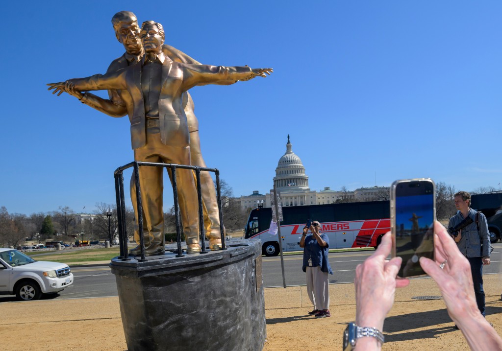 People take photos of protest art representing President Donald Trump and Jeffrey Epstein on the National Mall near the Capitol, Tuesday, March 10, 2026, in Washington.