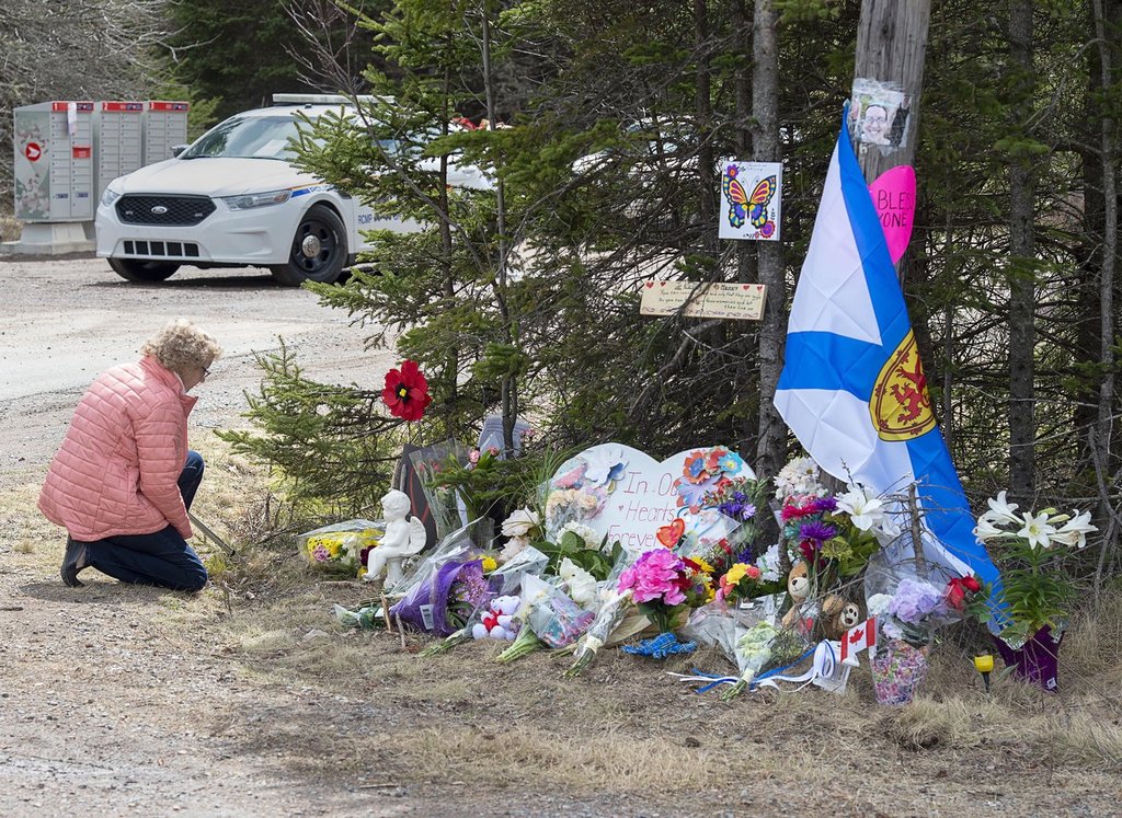 A woman pays her respects at a roadblock in Portapique, N.S. on Wednesday, April 22, 2020. THE CANADIAN PRESS/Andrew Vaughan.