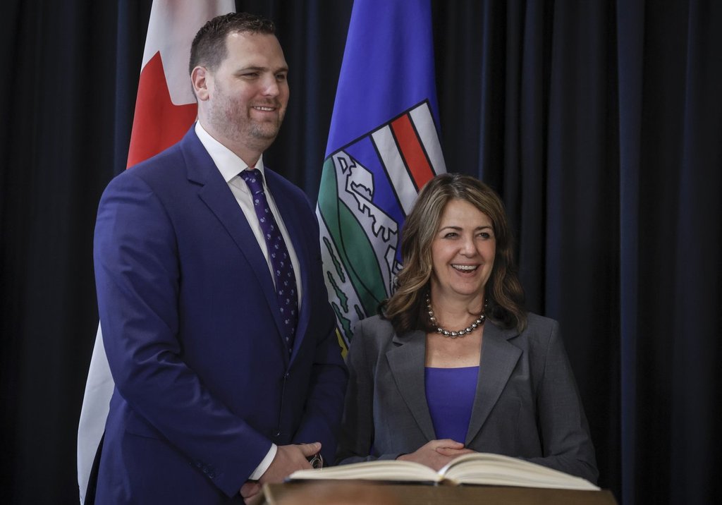 Alberta Premier Danielle Smith, right, stands with new Minister of Jobs, Economy, Trade, and Immigration, Joseph Schow, following a swearing in ceremony in Calgary, Friday, May 16, 2025.