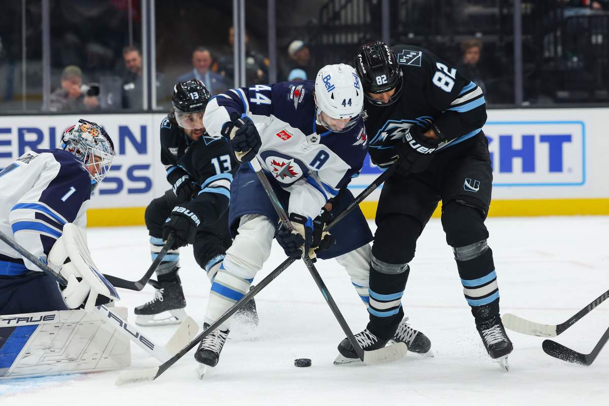 Utah Mammoth center Kevin Stenlund (82) fights for the puck against Winnipeg Jets defense Josh Morrissey (44) during the first period of an NHL hockey game, Tuesday, April 14, 2026, in Salt Lake City. (AP Photo/Melissa Majchrzak).