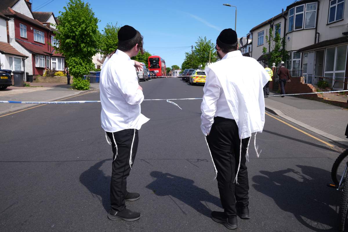 Members of the Jewish community stand at the scene where two people were stabbed, in Golders Green neighborhood, that has a large Jewish community, in London, Wednesday April 29, 2026.
