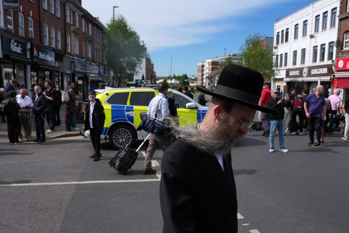 A man walks past a blocked road after two people were stabbed in Golders Green neighbourhood, that has a large Jewish community, in London, Wednesday, April 29, 2026.