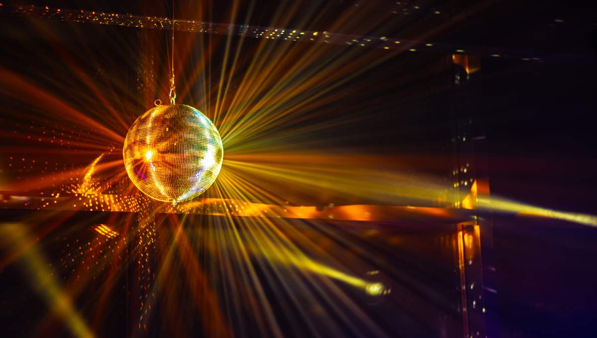 Shiny disco balls on color background with blurred lights, space for text. Bokeh effect