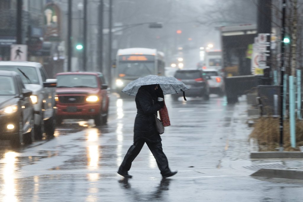 A pedestrian walks through the rain and wind during a rainfall warning in Halifax on Thursday, Jan. 26, 2023. 
