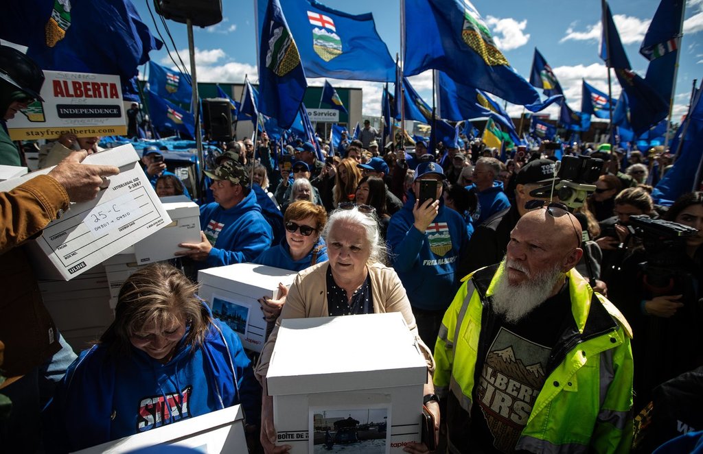 Supporters carry boxes of signatures to submit for a separation referendum to Elections Alberta in Edmonton, on Monday, May 4, 2026.