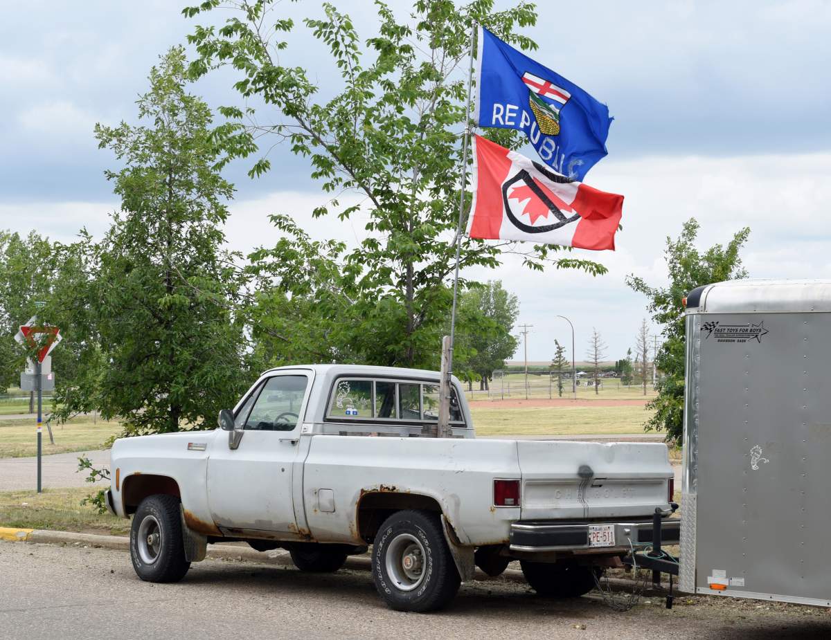 A pickup truck flying a modified Alberta provincial flag with the word Republic added and an upside down Canadian flag with a No symbol on it is pictured in Oyen, Alberta on June 20, 2025. 