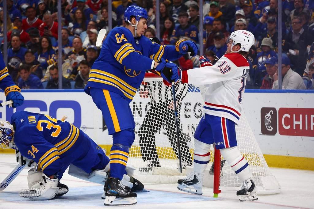 Montreal Canadiens winger Cole Caufield (13) is pushed out of the crease by Sabres defenceman Logan Stanley (64) during the second period of Game 1 in Buffalo, N.Y., on Wednesday, May 6.