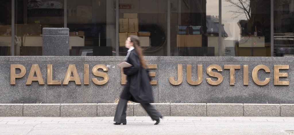 A lawyer walks past the courthouse in Montreal on Tuesday, April 21, 2026. THE CANADIAN PRESS/Christinne Muschi.