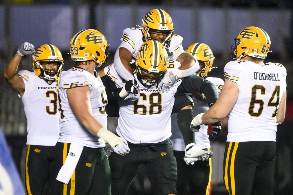 Edmonton Elks' running back Justin Rankin (5) jumps on the back of his teammate and offensive lineman Jordan Murray (68) following his touchdown against the Ottawa Redblacks during second half regular season CFL action in Ottawa, on Saturday, June 6, 2026. THE CANADIAN PRESS/Spencer Colby.