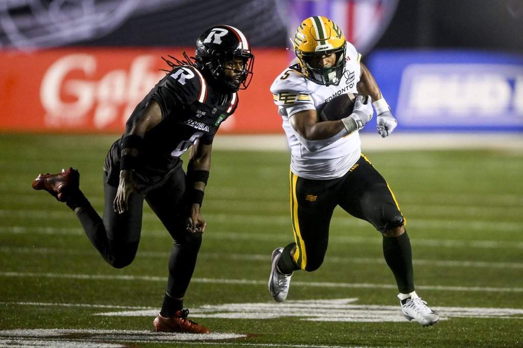 Edmonton Elks' running back Justin Rankin (5) evades a tackle by Ottawa Redblacks' defensive back CJ Reavis (8) during second half regular season CFL action in Ottawa, on Saturday, June 6, 2026. THE CANADIAN PRESS/Spencer Colby.
