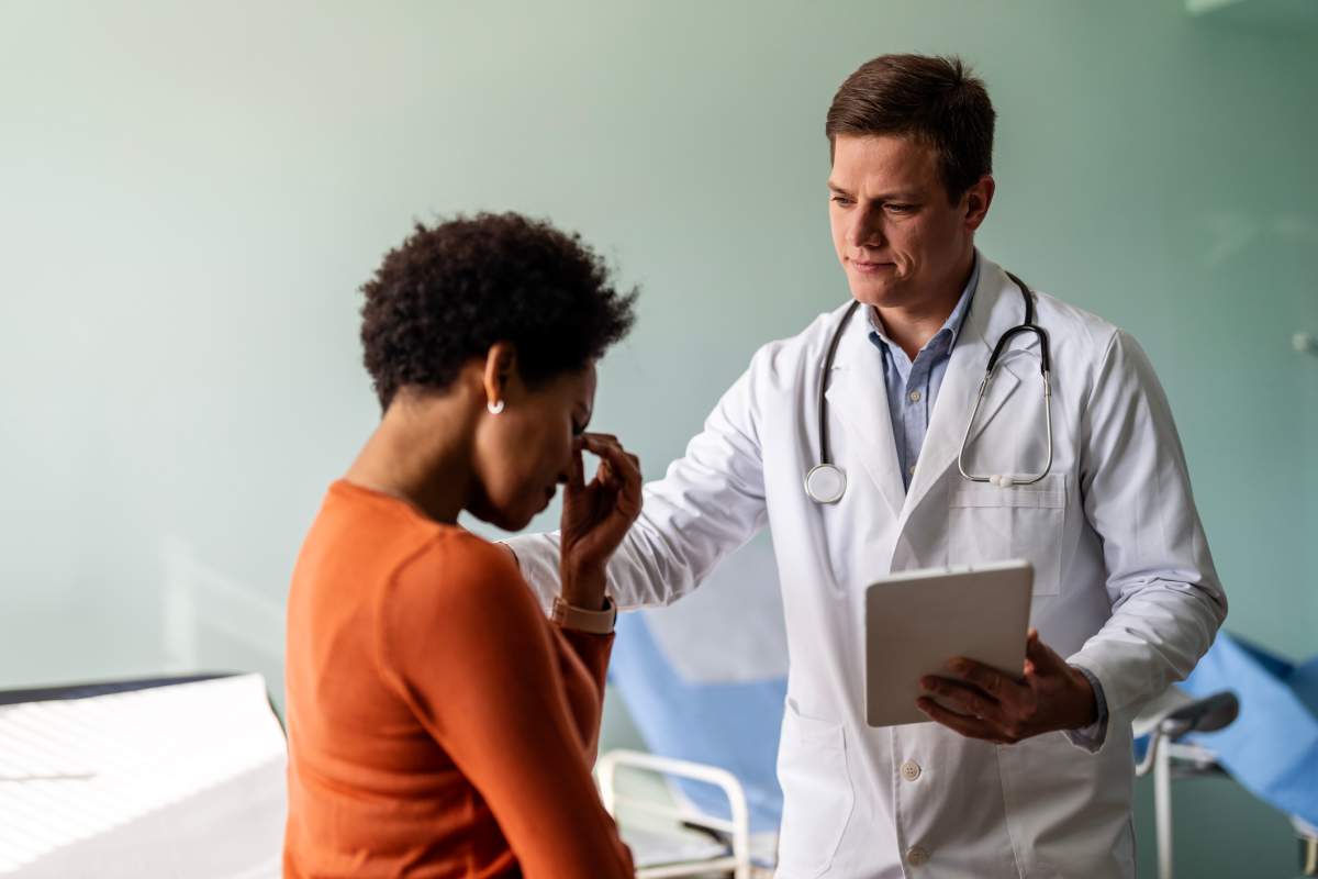 A doctor comforts an upset patient during an appointment. Ljubaphoto/Getty Images