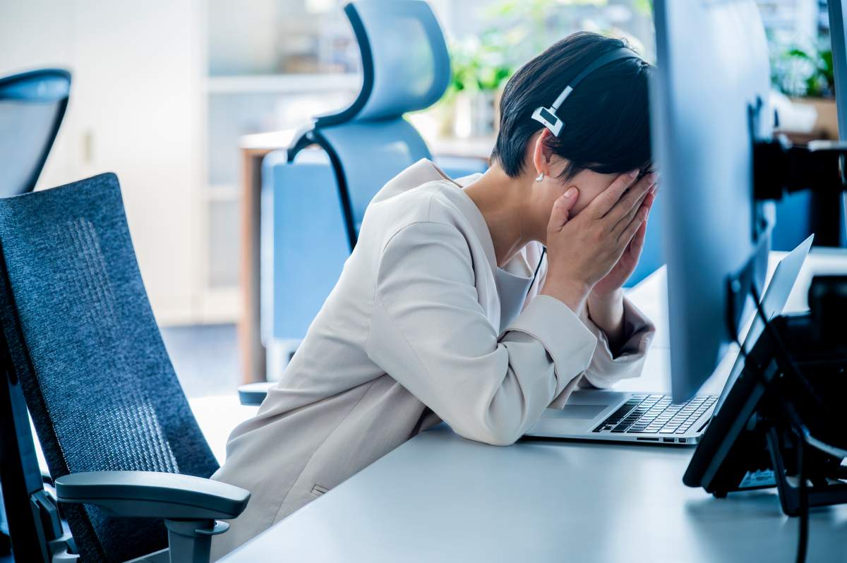 An administrative assistant cries at her desk after receiving a layoff notice. Michael H/Getty Images