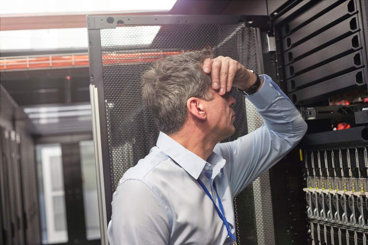 A tech worker rubs his forehead after learning that he’s being let go. Caia Image/Getty Images