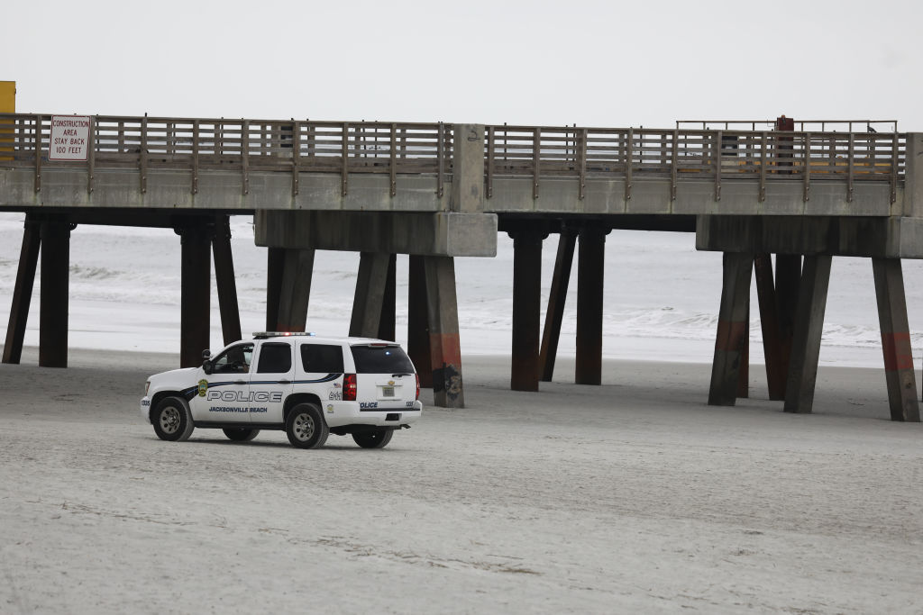 FILE: Police officers patrol the beach in Jacksonville Beach, Florida, U.S., on Saturday, April 18, 2020