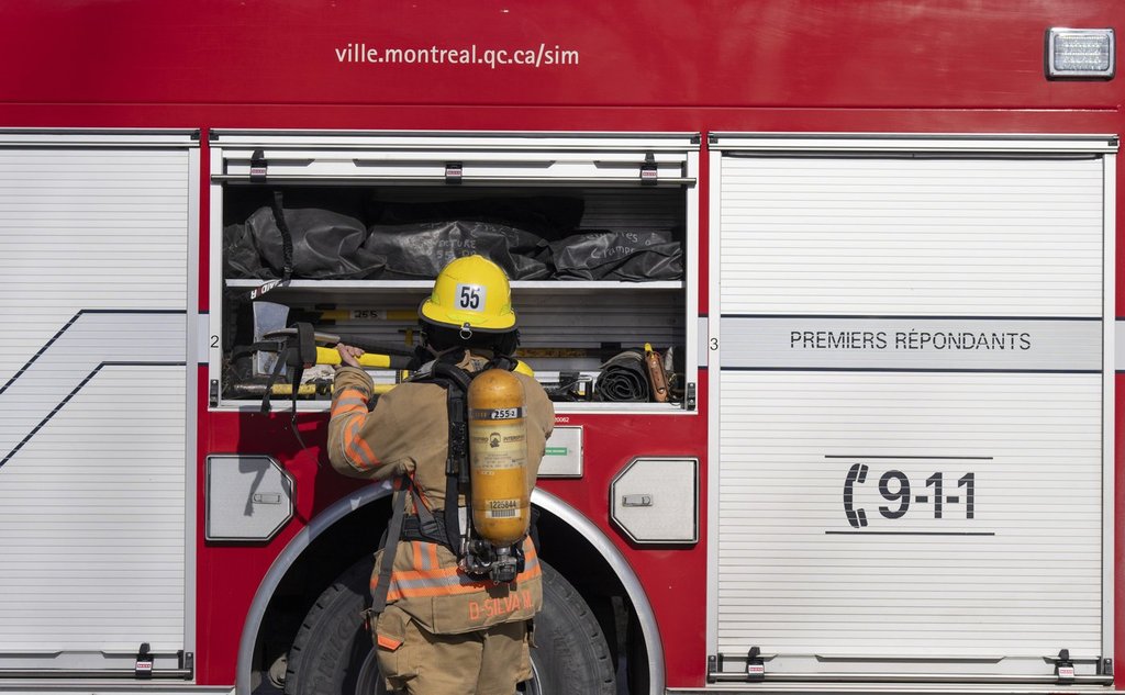 A firefighter puts gear away after responding to an alarm in Pointe Claire, a borough of Montreal, Thursday March 7, 2024. THE CANADIAN PRESS/Christinne Muschi.