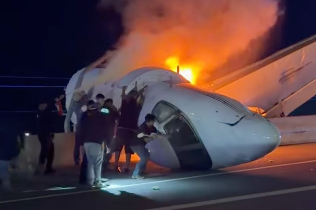 People attempt to pull passengers out of a plane after it crashed on a highway Tuesday, June 16, 2026, in Laredo, Texas.