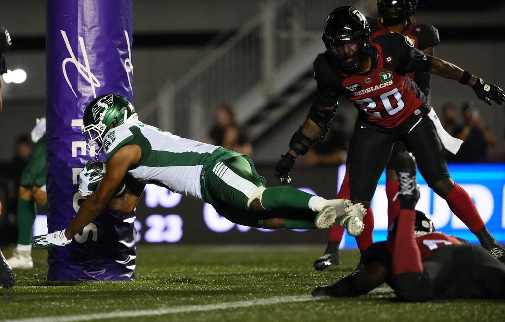 Saskatchewan RoughridersÕ KeeSean Johnson (3) scores a touchdown past Ottawa RedblacksÕ A.J. Allen (bottom right) during second half CFL football action in Ottawa on Friday, July 3, 2026. THE CANADIAN PRESS/Justin Tang.