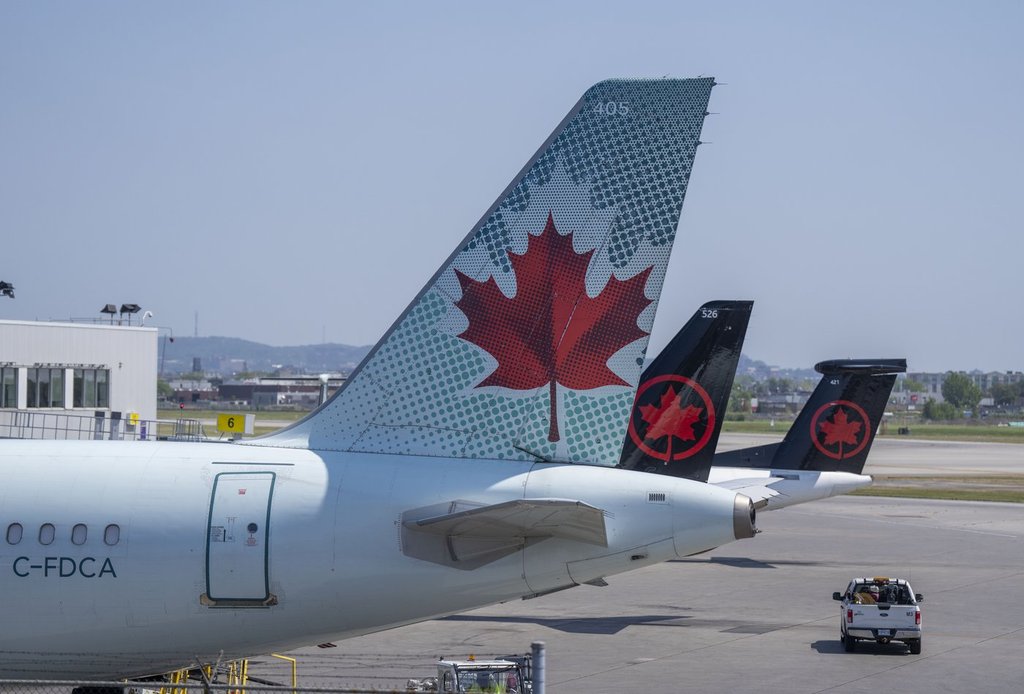 Air Canada planes sit on the tarmac at Montreal-Pierre Elliott Trudeau International Airport in Montreal, on Monday, Aug. 11, 2025. 
