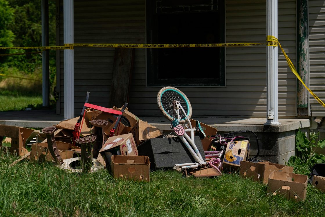 Police tape and debris are seen at a home where authorities say they removed 16 children and arrested four adults in Hamden, Ohio, July 1, 2026.