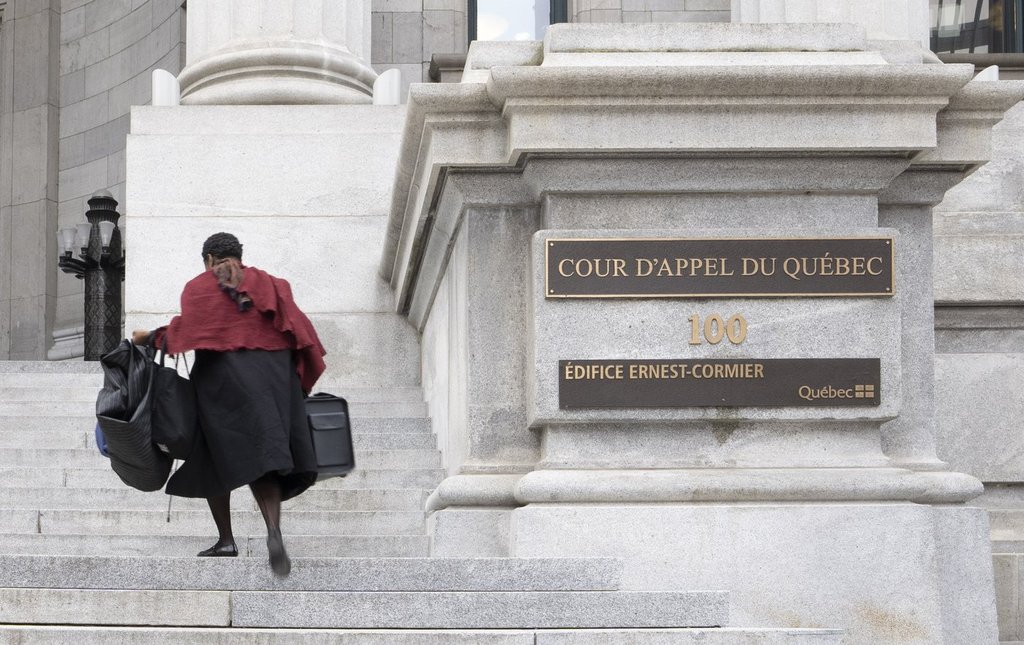 A lawyer runs up the steps of the Quebec Court of Appeal in Montreal on Tuesday, April 21, 2026.  