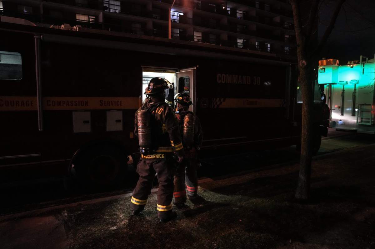 Members of the Toronto fire department gather outside a building in Thorncliffe Park in Toronto on Dec. 1, 2025. Numerous residents in two connected residential buildings were evacuated after insulation began burning in between the walls.