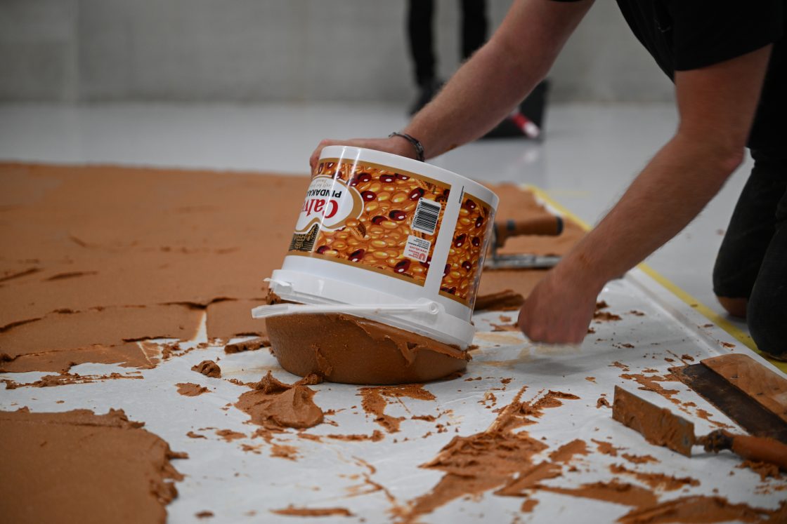 Workers spread peanut butter on a floor to recreate the 'Peanut Butter Floor' artwork in tribute to Dutch artist Wim T. Schippers at the Museum Boijmans Van Beuningen in Rotterdam, Netherlands, July 3, 2026.