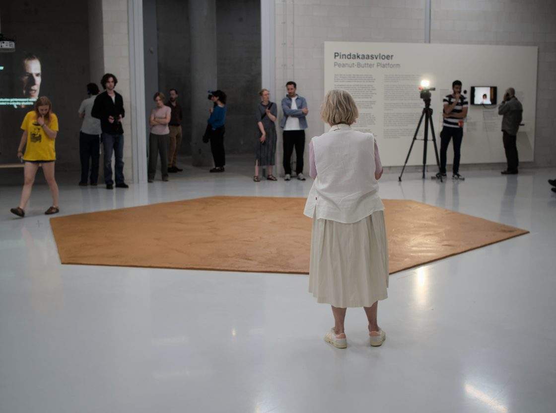 People look at the peanut butter floor spread across a museum floor in tribute to Dutch artist Wim T. Schippers, who died last month, in Rotterdam, the Netherlands, Thursday, July 9, 2026.